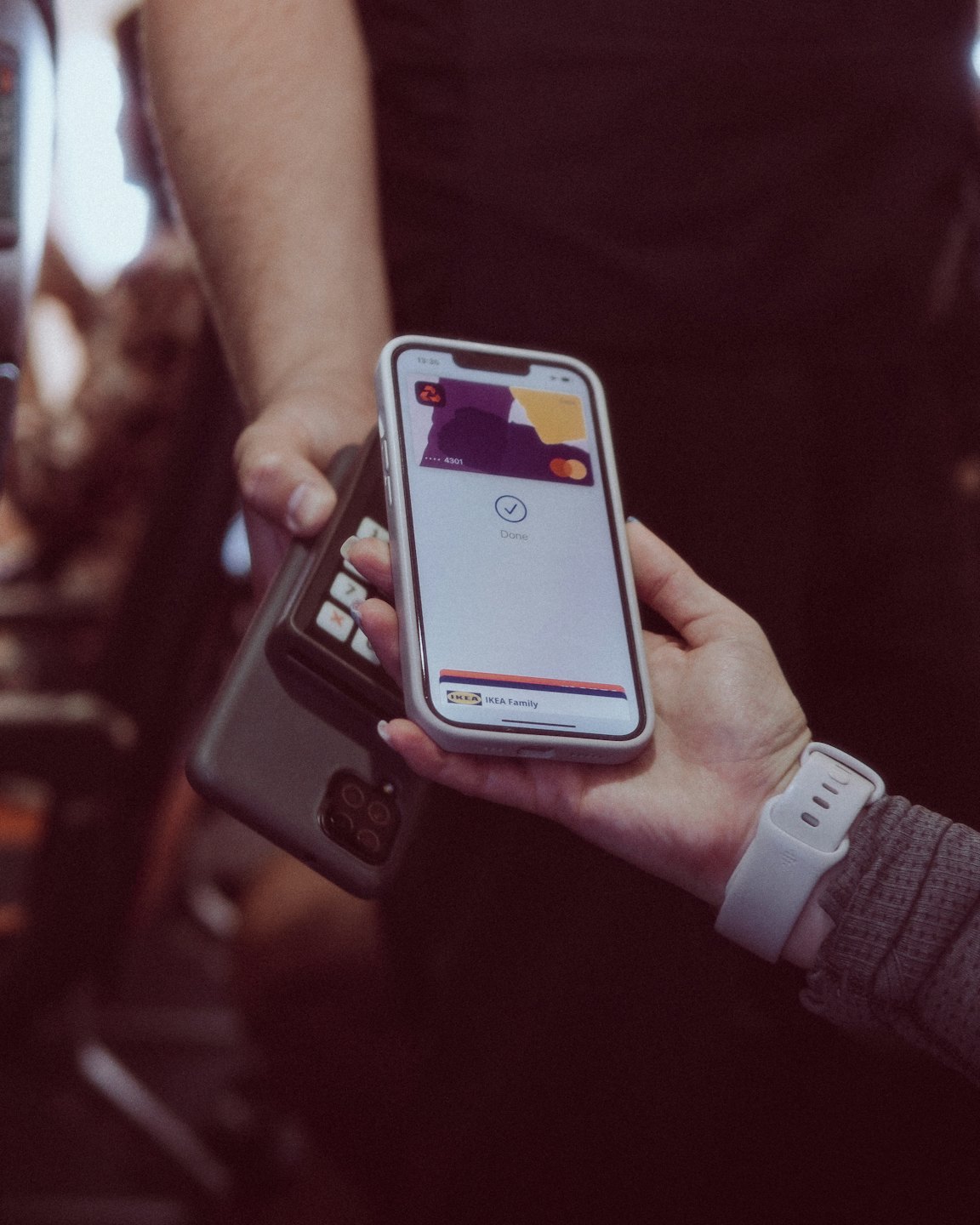 Two people completing a mobile payment transaction indoors.