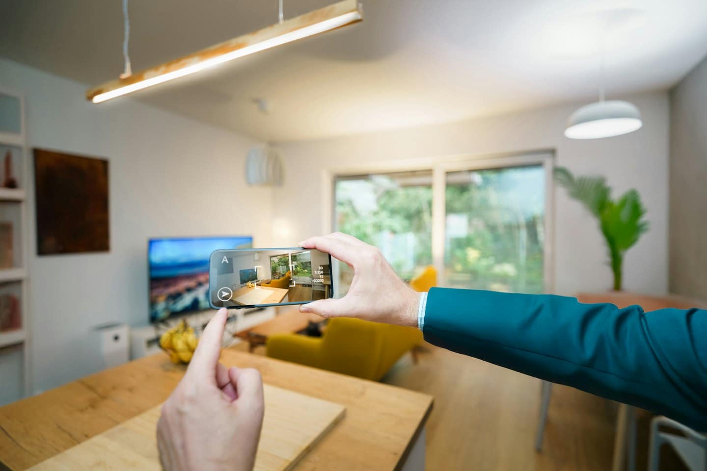 Hands holding phone showing augmented reality interior design app.